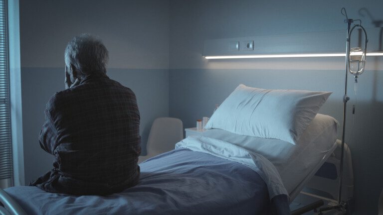 Senior sitting alone in a hospital bed